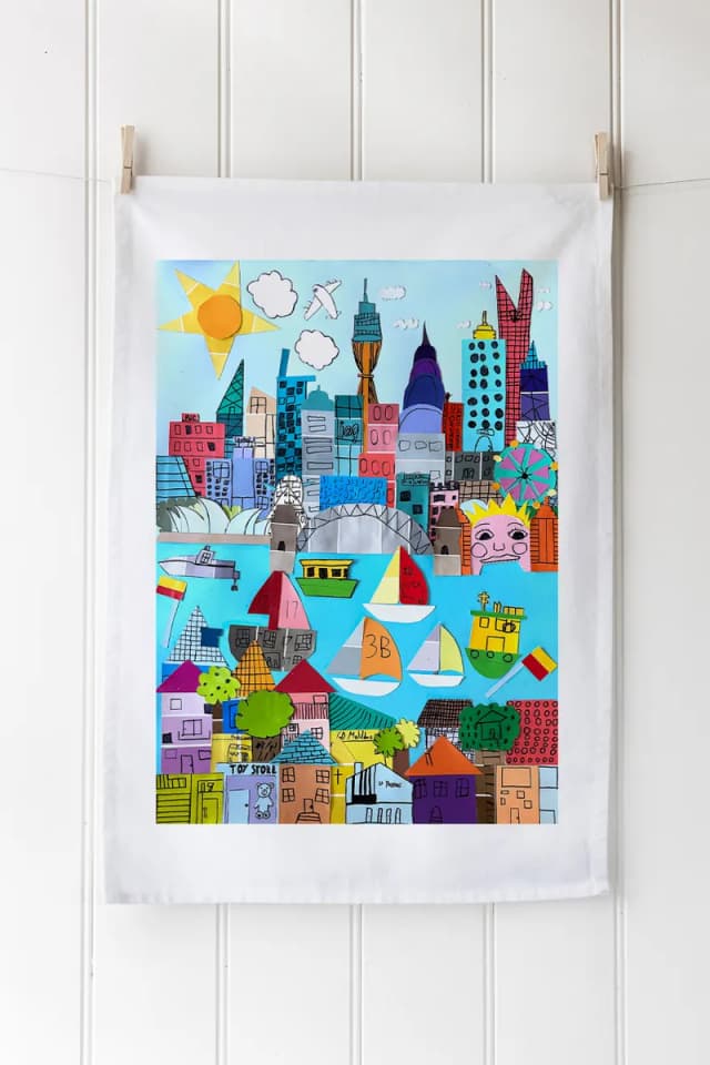 A tea towel digitally printed with a colourful painted cityscape