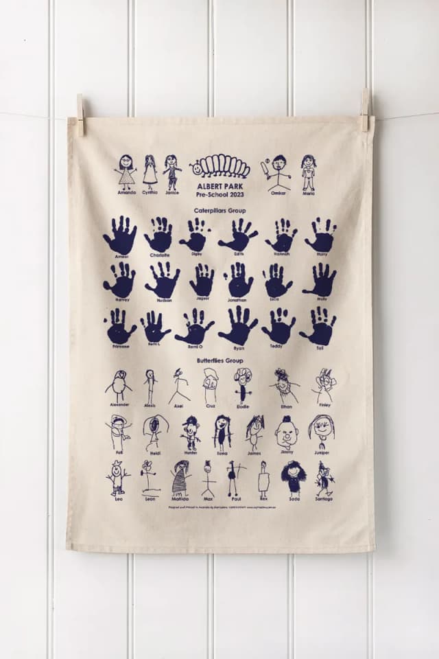 A natural tea towel screen printed with handprints and portraits